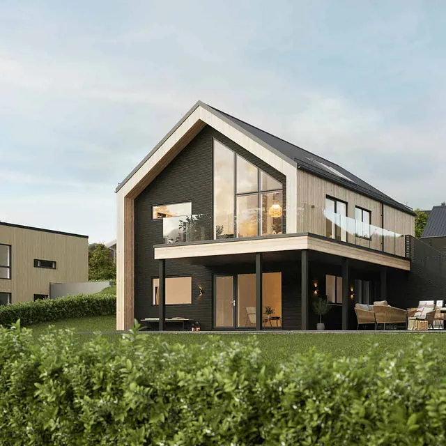 Moderne tomannsbolig med svart og trepanel, stor veranda og hage i skrått terreng.